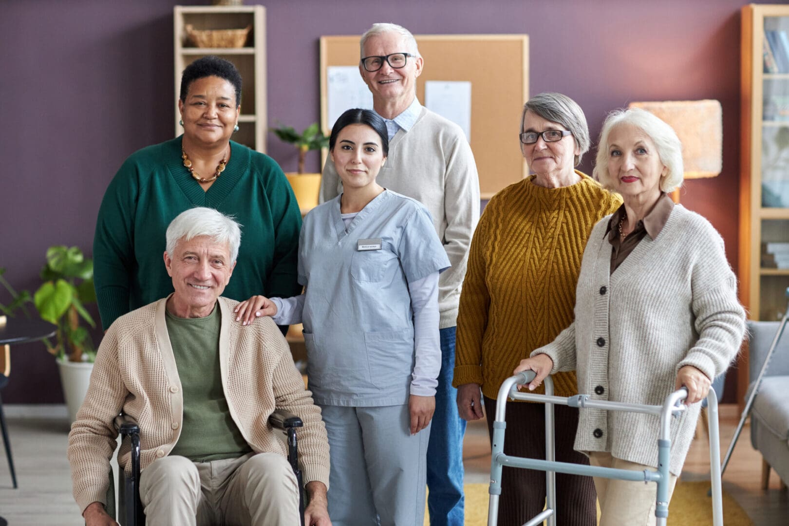 Group of seniors with a caregiver smiling.