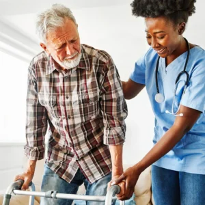 Nurse assisting elderly man with walker for support.
