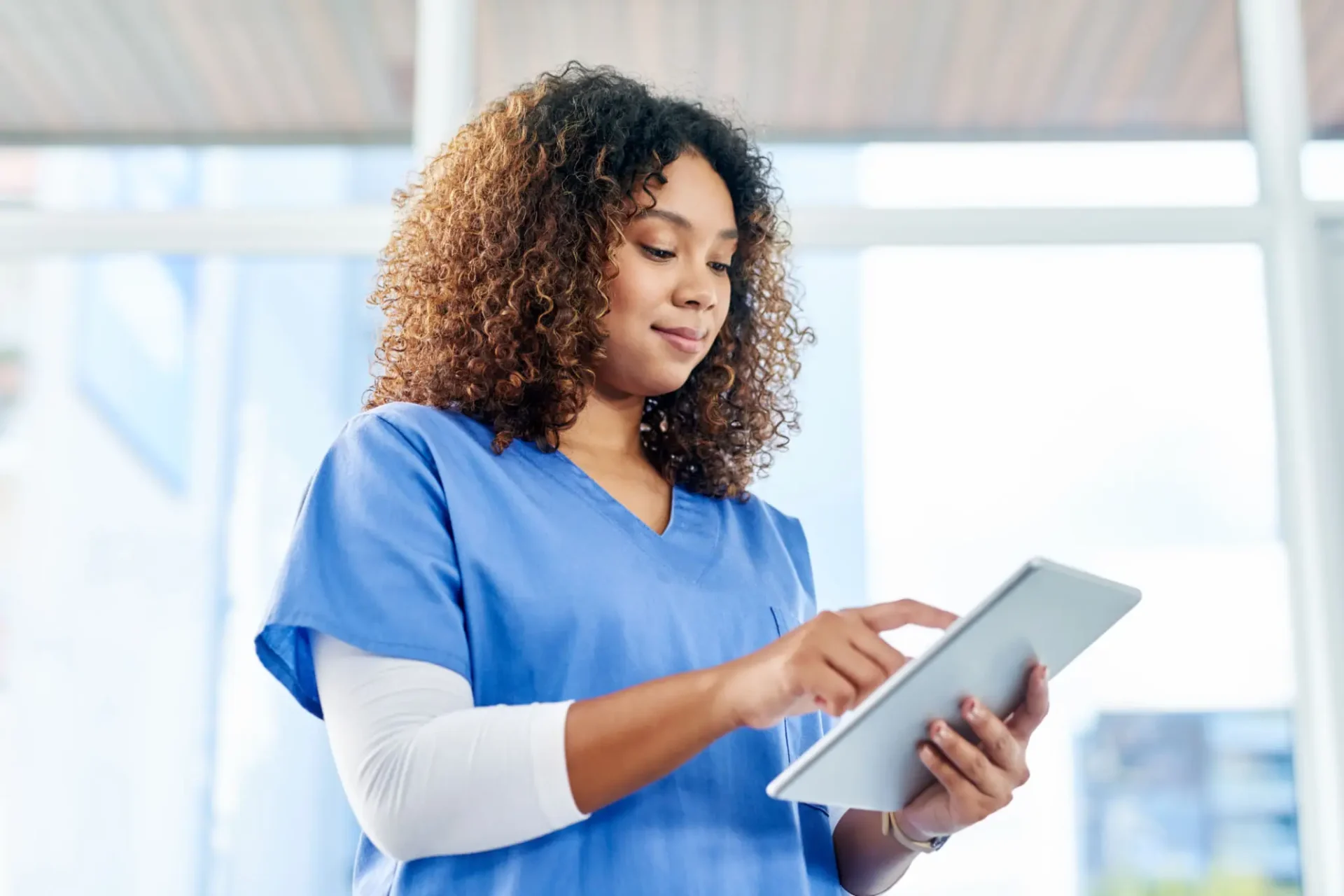 Healthcare professional using a digital tablet.