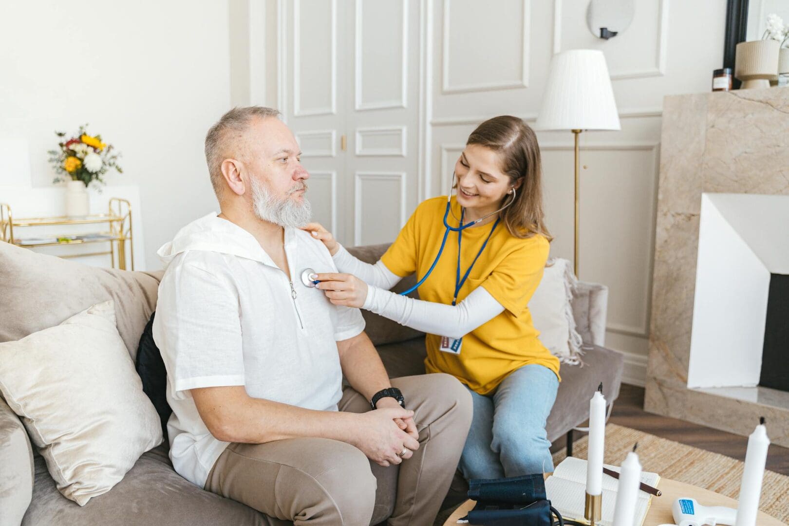 A healthcare worker checks a man's blood pressure at home.